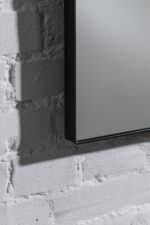 Detaljbild kvadratisk spegel med svart metallram