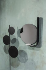 Rund dekorativ spegel med modern svart metallhylla