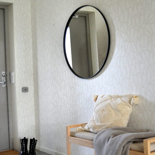 Rund hallspegel med svart aluminiumram och spegelglaset djupare i ramen