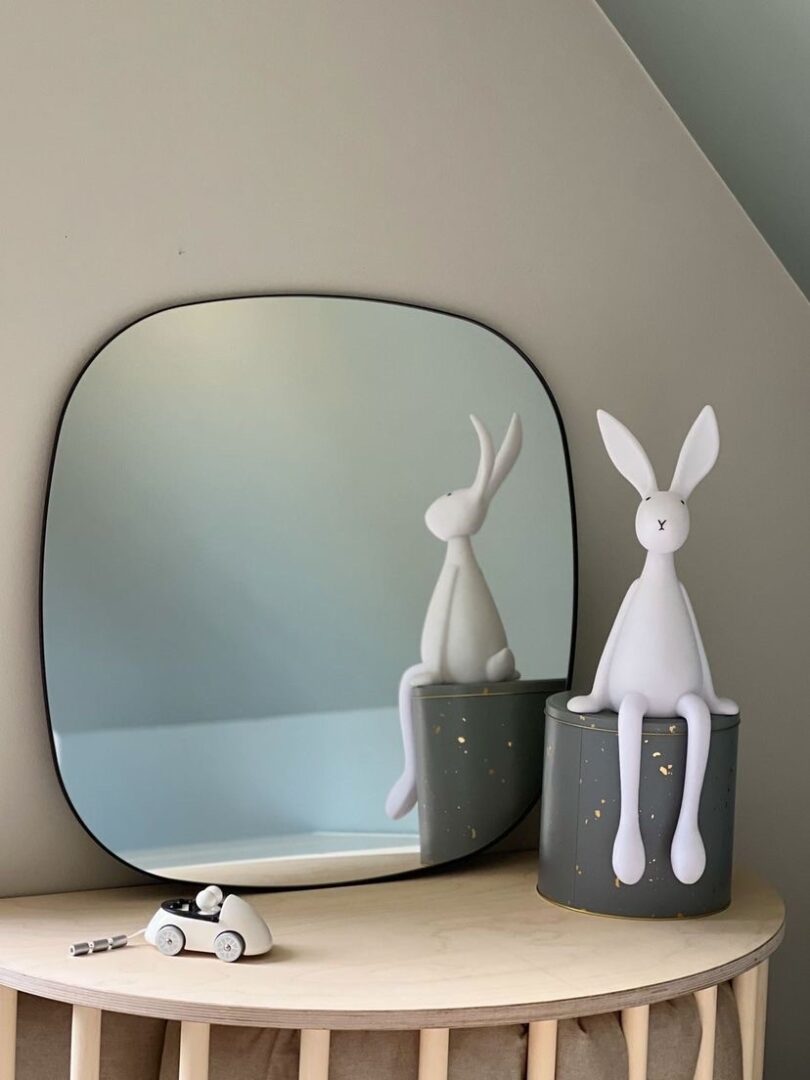 Modern spegel med svart metallram i barnrum